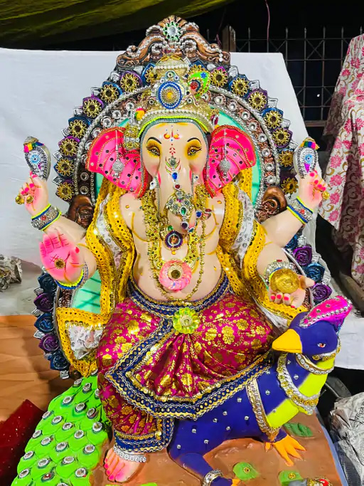 गणेशपर्व-रङ्गिणीप्रकाशैः, पुष्पैः अलङ्कृताः पण्डालः; गणपति बप्पा मोरया इति प्रतिध्वनित: