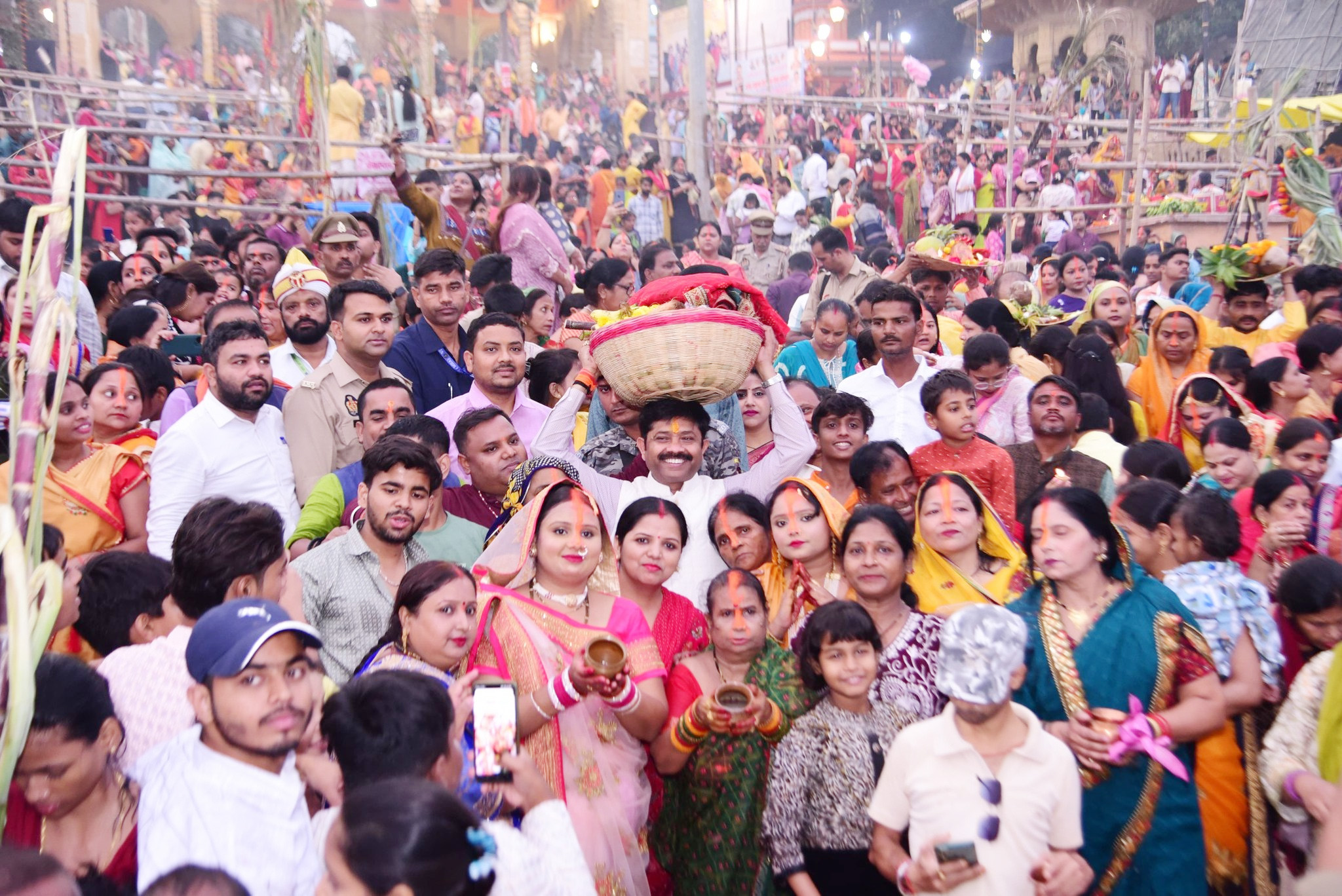 बलुआघाटबरादरीयां छठपूजायां मन्त्री नन्दी पूजायाः दउरां शिरसि वहन् छठ मातरं पूजयतिस्म